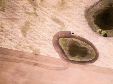 Aerial view of the tractor in the field, agricultural field work. Tractor cultivating field, aerial...