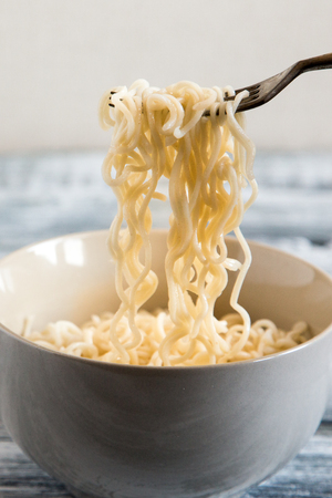 Instant noodles on wooden background. Cooked chinese instant noodles. Soup Ramen.の写真素材