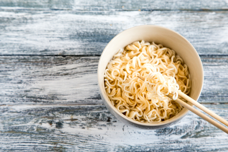 Instant noodles on wooden background. Cooked chinese instant noodles. Soup Ramen.の写真素材