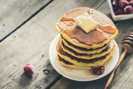 Sweet Homemade Stack of Pancakes with Butter, raspberryes and Honey for Breakfast/の写真素材