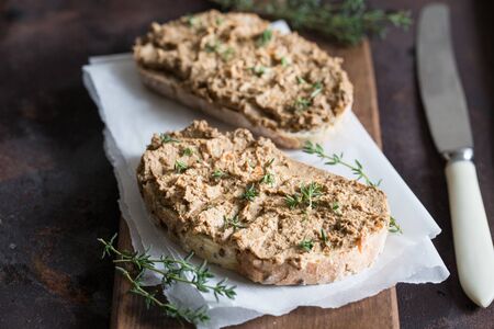 Fresh homemade chicken liver pate. Chicken liver pate on bread and in jar on a dark background/