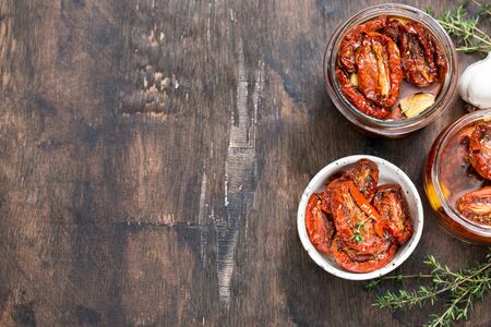 Sun dried tomatoes with olive oil in a jar on wooden background.の写真素材