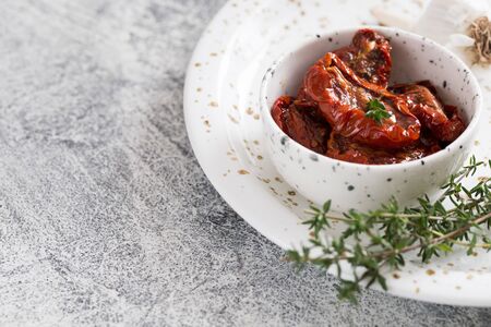 sun-dried tomatoes in a plate on a light concrete background.の写真素材
