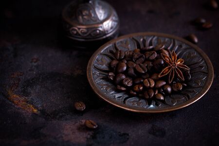 fresh roasted coffee beans on a beautiful plate on a rough rusty background. selective focus, copy space/の写真素材