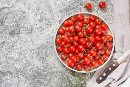 Tiny cherry tomatoes (ciliegini, pachino, cocktail). group of cherry tomatoes on a gray concrete background. ripe and juicy cherry tomatoes/の写真素材