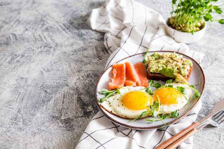 Egg breakfast. Healthy nutritious breakfast with eggs, salmon, avocado sandwich and sprouted pea seeds.の写真素材