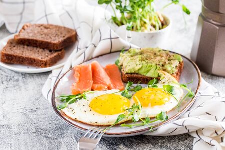 Egg breakfast. Healthy nutritious breakfast with eggs, salmon, avocado sandwich and sprouted pea seeds.の写真素材