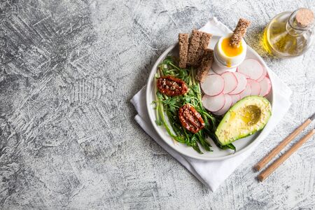 nutritious breakfast. wild garlic, sun-dried tomatoes, whole grain bread, avocado, seeds and boiled egg. good nutrition conceptの写真素材