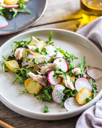 Fresh salad with radishes, potatoes, arugula and mackerel or tuna.の写真素材