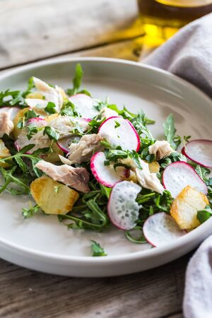 Fresh salad with radishes, potatoes, arugula and mackerel or tuna.の写真素材