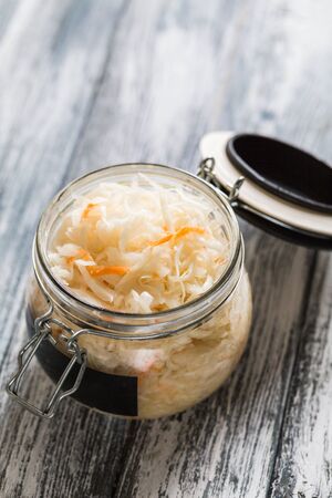 Sauerkraut fermented salad. Homemade fresh pickled cabbage (german sauerkraut) with ingredients in jarの写真素材