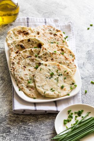 Onion naan - traditional indian bread. pita bread or scones with green onionsの写真素材