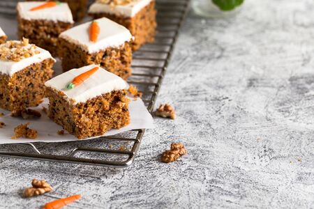 pieces of carrot cake with walnuts with icing cream on a light background. tinting. selective focus/の写真素材