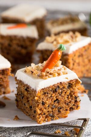 pieces of carrot cake with walnuts with icing cream on a light background. tinting. selective focus/の写真素材