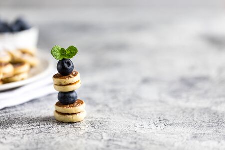 Tiny pancakes for breakfast. mini pancakes on a skewer with blueberries. Copy space for text or designの写真素材