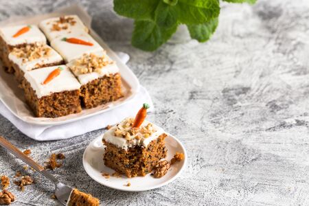 pieces of carrot cake with walnuts with icing cream on a light background. tinting. selective focus/の写真素材