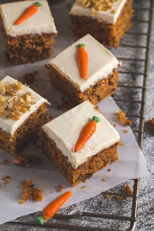 pieces of carrot cake with walnuts with icing cream on a light background. tinting. selective focus/の写真素材