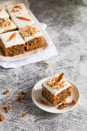 pieces of carrot cake with walnuts with icing cream on a light background. tinting. selective focus/の写真素材