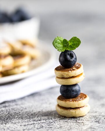 Tiny pancakes for breakfast. mini pancakes on a skewer with blueberries. Selective focusの写真素材