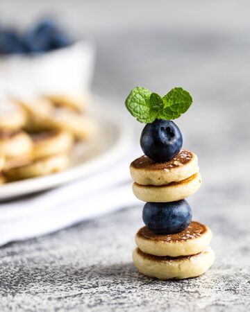Tiny pancakes for breakfast. mini pancakes on a skewer with blueberries. Selective focusの写真素材