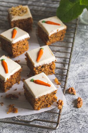 pieces of carrot cake with walnuts with icing cream on a light background. tinting. selective focus/の写真素材