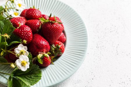 Fresh juicy strawberries with leaves on light  table. Strawberry.の写真素材
