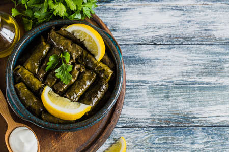 Dolma - Stuffed greek wine leaves (dolmades) on a blue wooden backgroundの写真素材