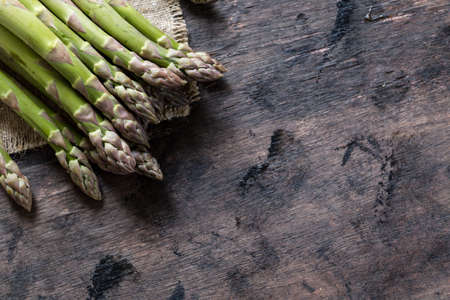 Green Asparagus. Bunches of green asparagus on a dark wooden rustic backgroundの写真素材