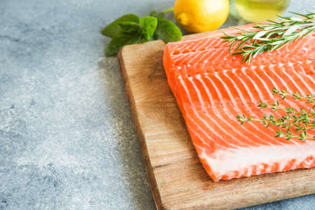 Salmon. Fresh raw salmon fish fillet with cooking ingredients, herbs and lemon. Close up. healthy food, diet or cooking conceptの写真素材