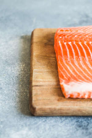 Salmon. Fresh raw salmon fish fillet with cooking ingredients, herbs and lemon. Close up. healthy food, diet or cooking conceptの写真素材