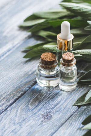 Sage oil in bottle on the vintage wooden table, selective focusの写真素材