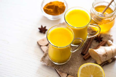 Turmeric tea drinks with milk and honey for beauty and health. Spicy healthy haldiの写真素材