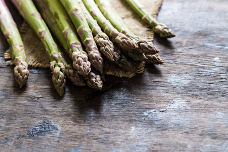 Green Asparagus. Bunches of green asparagus on a dark wooden rustic backgroundの写真素材