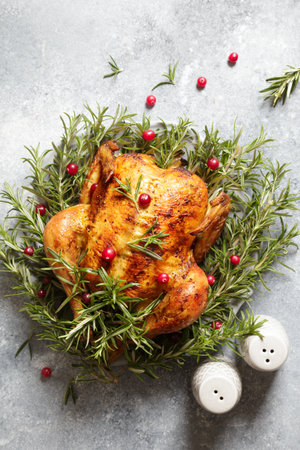 baked whole chicken with rosemary garlic and cranberries on gray concrete background. roasted chicken.の写真素材