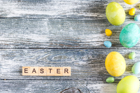 colorful easter eggs on shabby blue wooden background and "easter" lettersの写真素材