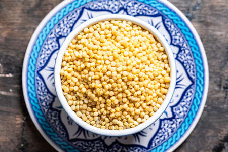Dry ptitim close-up. Toasted pasta ptitim (petit plomb or Israeli couscous) on a wooden backgroundの写真素材