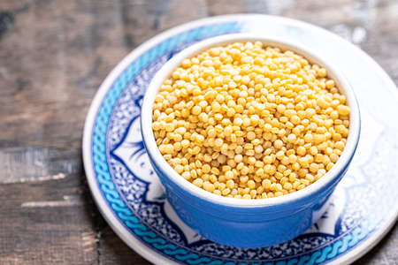 Dry ptitim close-up. Toasted pasta ptitim (petit plomb or Israeli couscous) on a wooden backgroundの写真素材