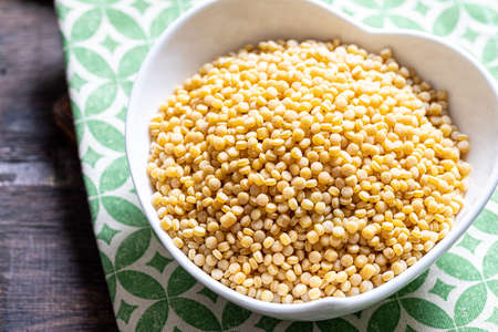 Dry ptitim close-up. Toasted pasta ptitim (petit plomb or Israeli couscous) on a wooden backgroundの写真素材