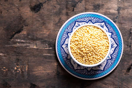 Dry ptitim close-up. Toasted pasta ptitim (petit plomb or Israeli couscous) on a wooden backgroundの写真素材