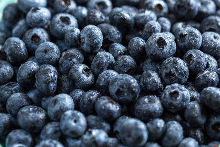 Fresh juicy blueberries background. Flat lay top view copy space. Healthy berry, organic food, antioxidant, vitamin, blue food.の写真素材