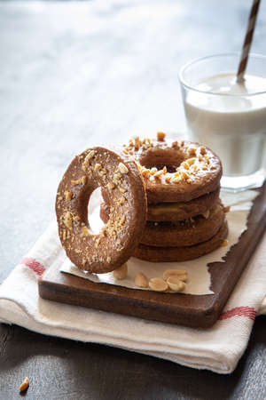 a stack of shortbread homemade cookies with peanuts on a wooden background with milk. peanut cookie.の写真素材