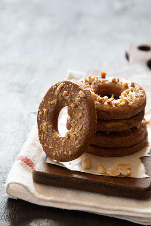 a stack of shortbread homemade cookies with peanuts on a wooden background with milk. peanut cookie.の写真素材