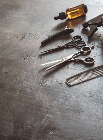 Set of professional hairdresser tools with combs and styling on dark wooden background top view mock up.の写真素材