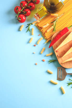 Uncooked pasta on blue background. Top view. Raw pasta with ingredients for cooking. Food concept. Italian food.の写真素材