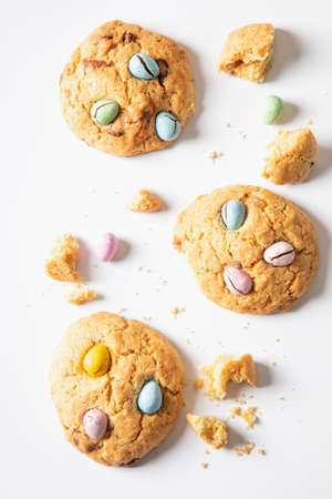 homemade cookies chocolate chips with colored candy eggs on a white background, top view.の写真素材