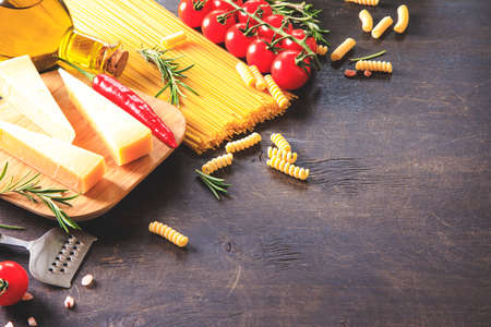 Uncooked pasta on wooden background. Top view. Raw pasta with ingredients for cooking. Food concept. Italian food.の写真素材