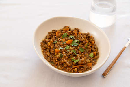lentils with vegetables in a plate on the dining table. comfort homemade food, vegetarian lentils.の写真素材