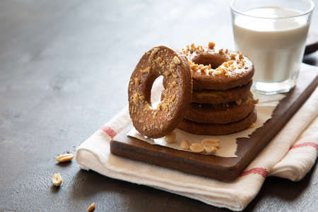 a stack of shortbread homemade cookies with peanuts on a wooden background with milk. peanut cookie.の写真素材