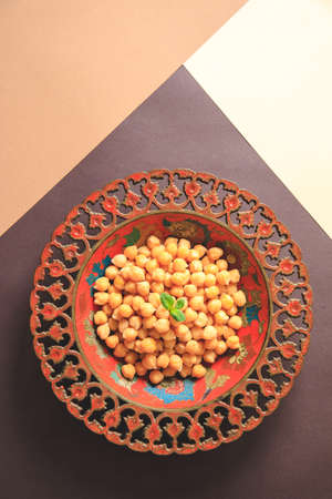 Cooked chick peas in a beautiful authentic plate. Spilled chick peas. Top viewの写真素材
