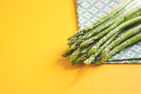 Asparagus. Fresh Asparagus. Pickled Green Asparagus. Bunches of green asparagus on yellow.の写真素材